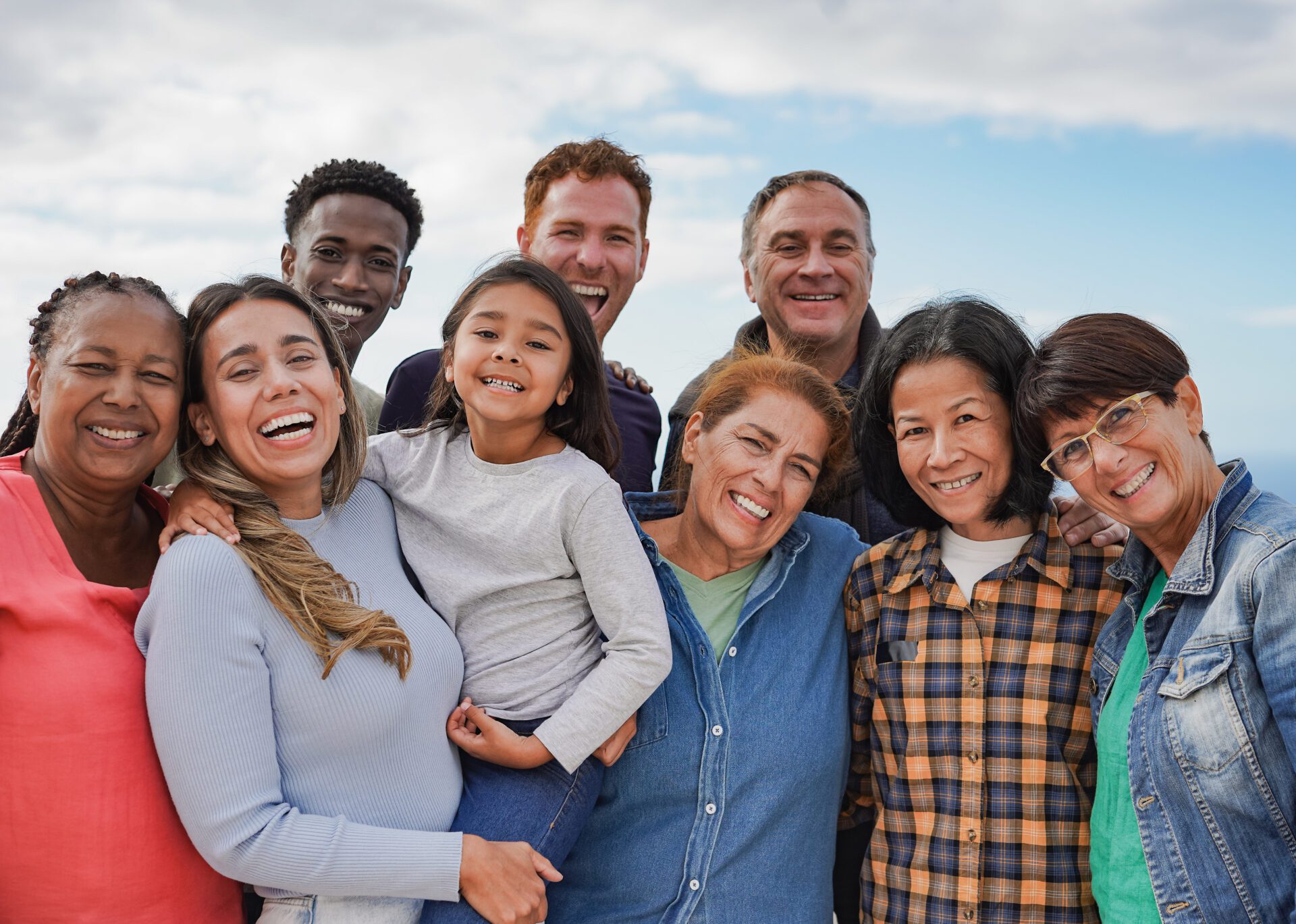 Multi generational friends smiling on camera outdoor - Group of multiracial people with different ages having fun together outdoor