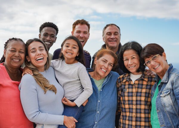 Multi generational friends smiling on camera outdoor - Group of multiracial people with different ages having fun together outdoor