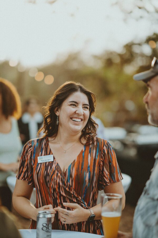 Board Chair, Stacie Ann Silva, shares a joyful conversation with an event attendee off-frame.